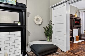 Ein Zimmer mit Kamin, einer Bank, einer Tür und einer Wanddekoration.