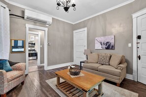 Ein Wohnzimmer mit einer Couch, einem Couchtisch und einer Deckenleuchte.
