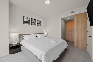 Ein modernes Schlafzimmer mit Bett, Nachttischen und einem Kleiderschrank.