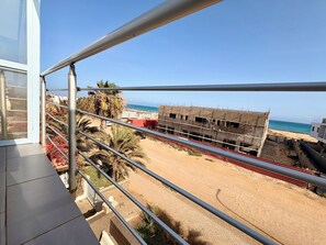 Ein Balkon mit Blick auf eine Baustelle und einen Strand.