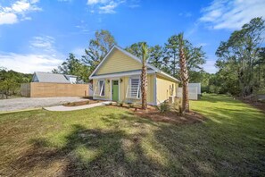 A single-story house with a sloped roof, a front porch, and a small front yard. - Outdoor Movie Theater/ Private POOL & Hot Tub/ Fun (Ocean Isle Beach)