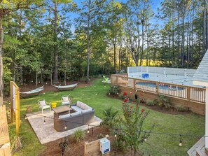 A backyard with a wooden deck, a barbecue area, and a hammock. - Outdoor Movie Theater/ Private POOL & Hot Tub/ Fun (Ocean Isle Beach)