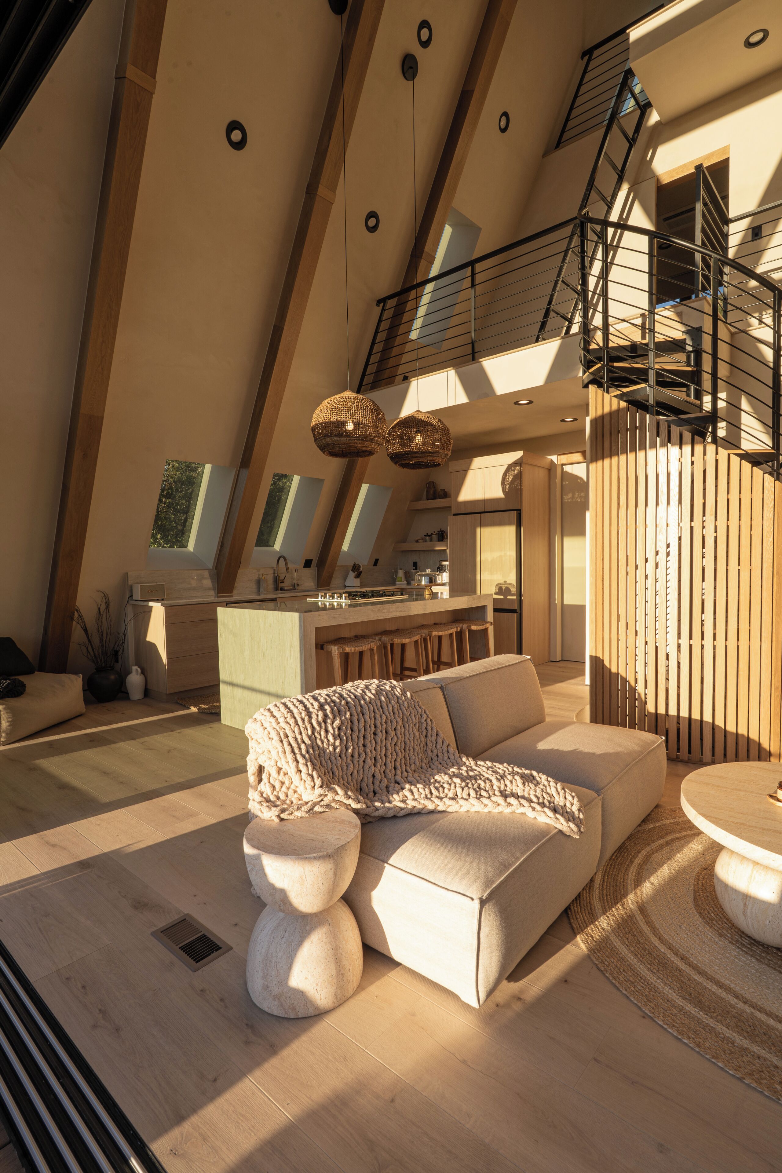Ein geräumiger Wohnbereich mit hohen Decken, einer Küche und einer Treppe, die in eine obere Etage führt.