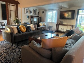 Ein Wohnzimmer mit einer Sofagarnitur, einem Couchtisch und einem Fernseher.