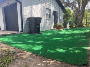 A residential property with a garage, a trash bin, and a well-maintained lawn. - Rainbow Springs Retreat — Your Perfect Dunnellon Getaway (Dunnellon)