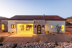 A modern two-story house with a stone facade, large windows, and a tiled roof. - NEW Modern Sanctuary | Minutes to Zion Desert | Pool, Spa and Game Room (Virgin)
