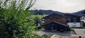A rustic building with a covered entrance and a car parked in front. - Ground floor, view ski slopes/village, terrace, tv, 51m², Les Gets (Les Gets)