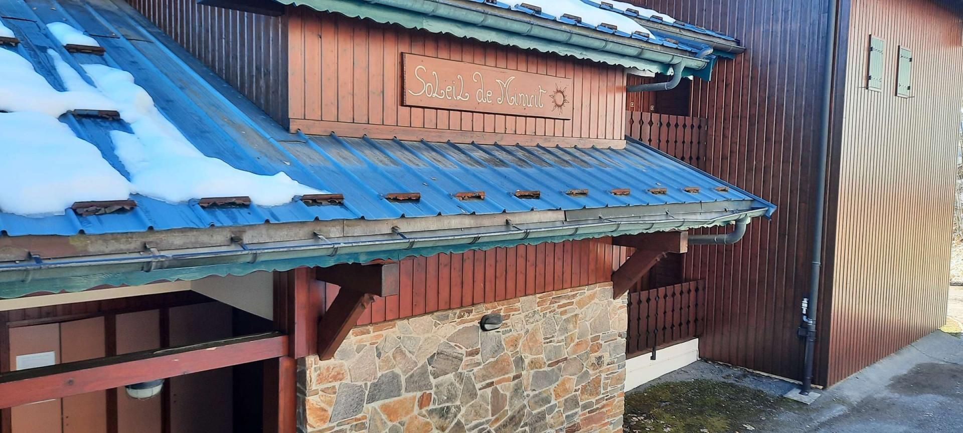 Un bâtiment doté d’un toit en tôle ondulée et d’une façade en bois.