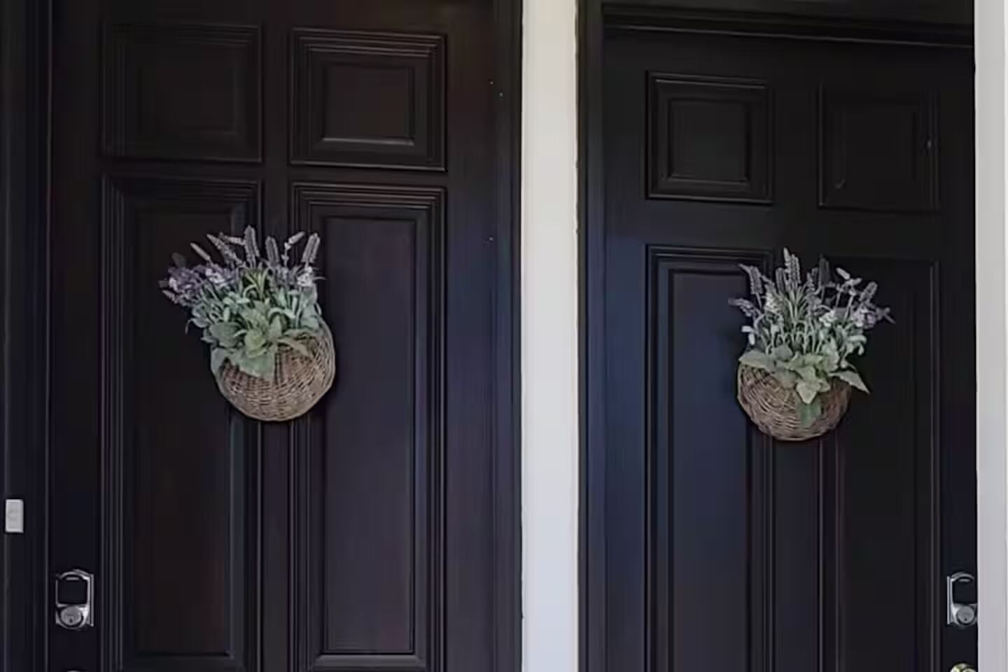 Two dark wooden doors with decorative baskets containing plants.