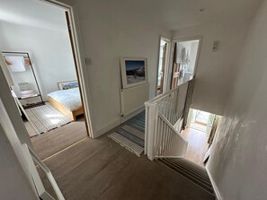 Ein Schlafzimmer mit einem Bett, einem Nachttisch, einem Heizkörper und einem Fenster.