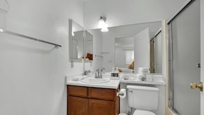 Un bany amb un lavabo blanc, un mirall i un vàter.