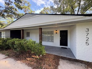 A single-story house with a white exterior, a black front door, and the number 3725 on the right side. - 3BR/2BA Modern & Spacious House Near UF - Great for Game Days or Commencements! (Gainesville)