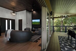 Una sala moderna con un sofá grande, un televisor de pantalla plana y una chimenea.