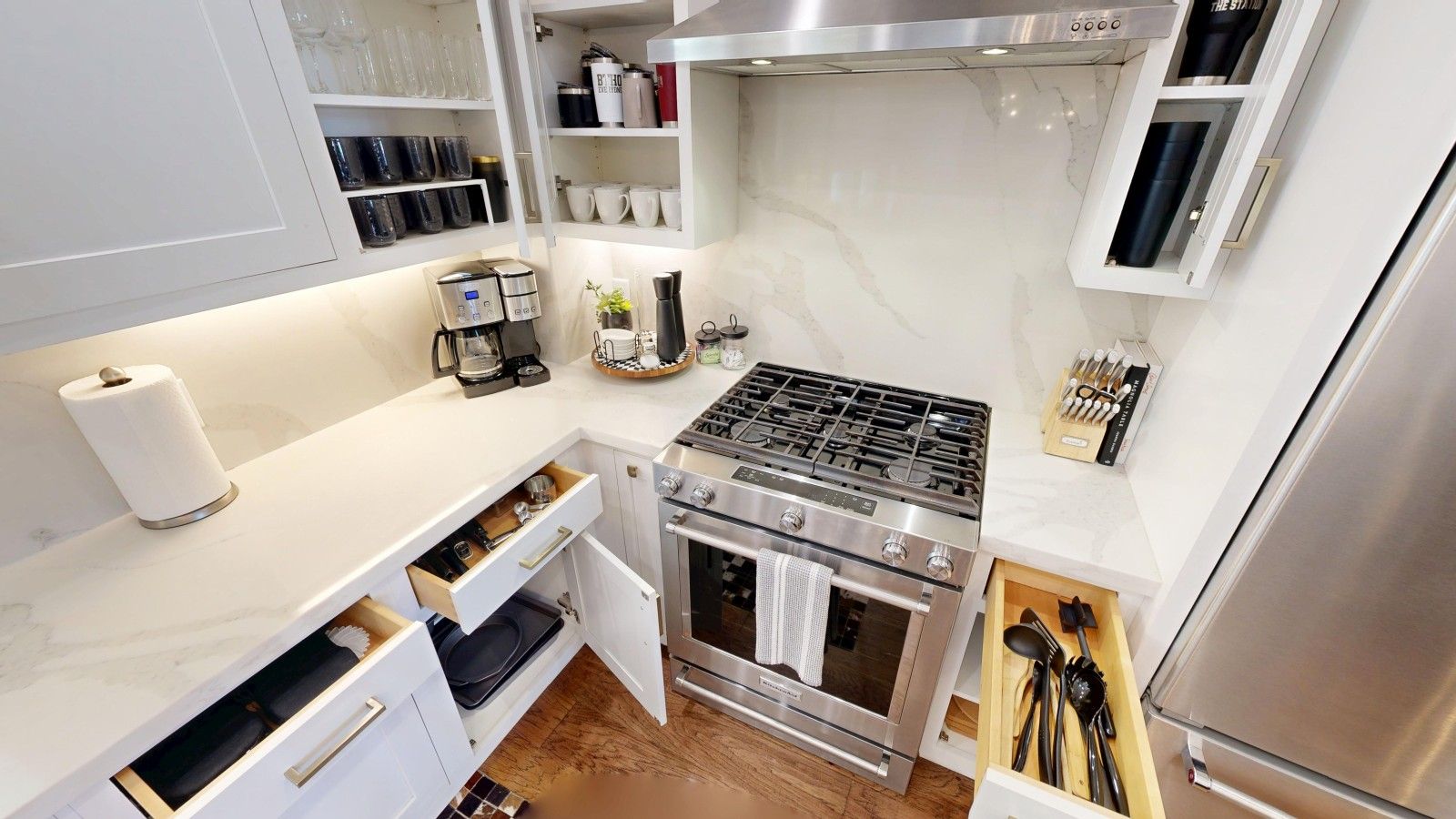 Une cuisine moderne équipée d’une cuisinière à gaz, d’un four et d’appareils électroménagers intégrés.