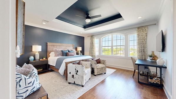 A bedroom with a large bed, a desk, and a chair.