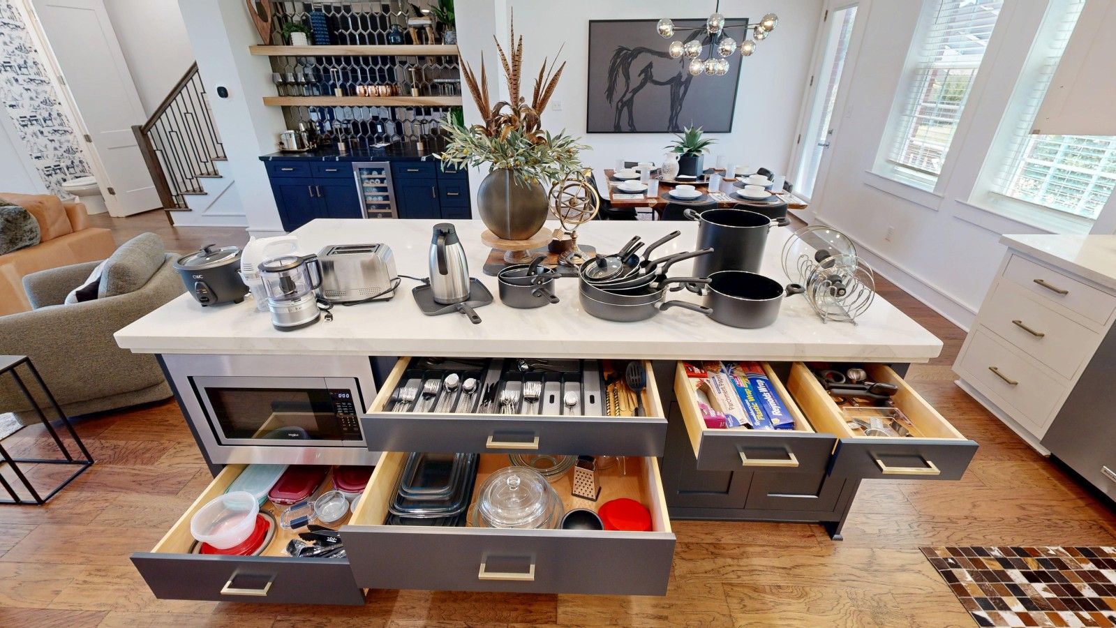 A modern kitchen with a central island, built-in appliances, and ample storage drawers.