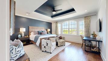 A bedroom with a large bed, a desk, and a chair.