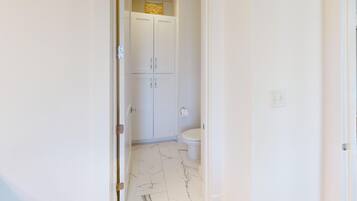 Une salle de bain avec des toilettes, un meuble et un sol en marbre.