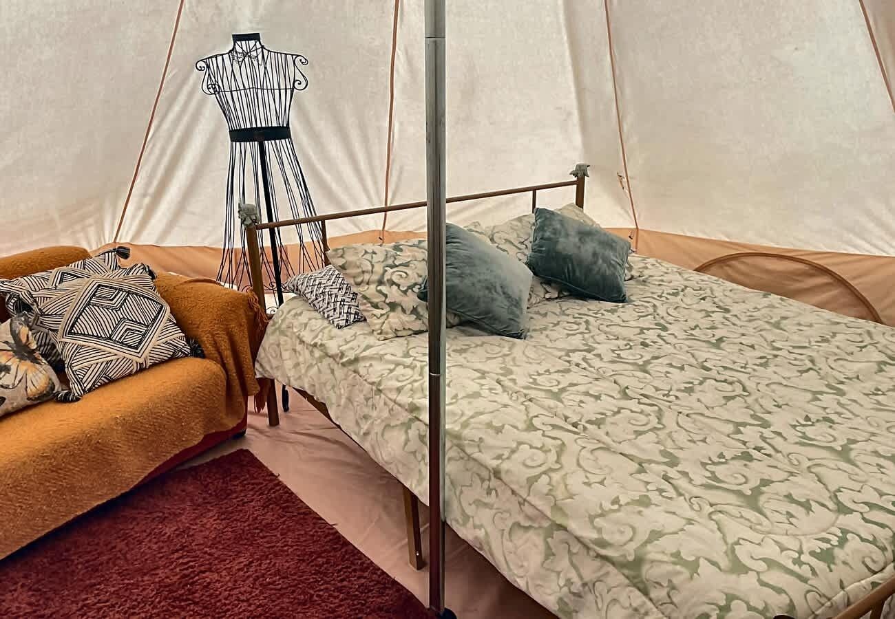 Ein Zelt mit einem Bett, einem Stuhl und einer Puppenfigur.