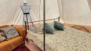 Ein Zelt mit einem Bett, einem Stuhl und einer Puppenfigur.