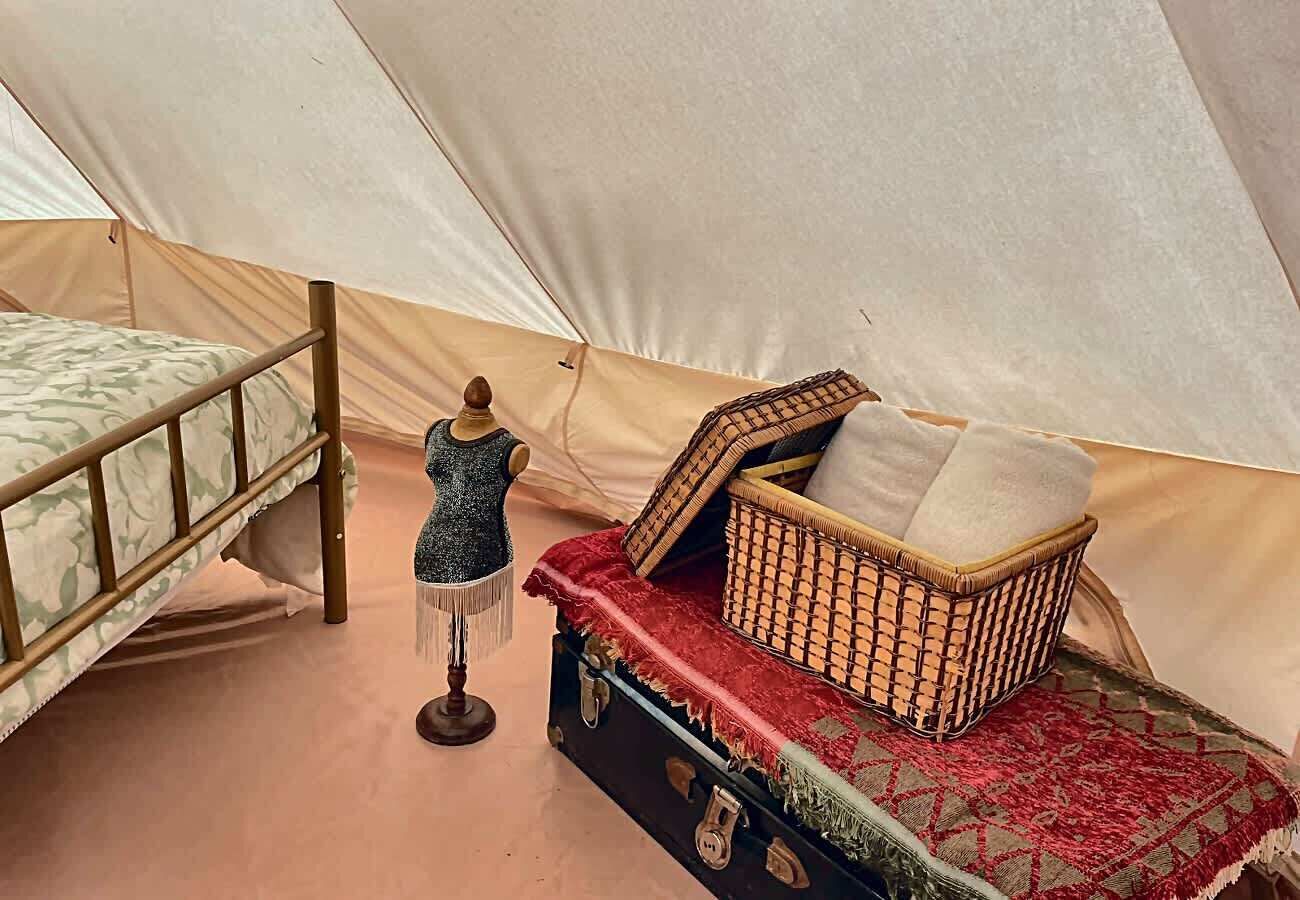 Ein Zelt mit einem Bett, einer Puppenstatue und einem Korb mit einem Kissen.