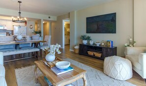 A living room with a dining area, a kitchen in the background, and a painting on the wall. - Sunswept 508 by ALBVR (Orange Beach)
