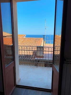 A balcony with a view of a coastal area, featuring terracotta rooftops and a clear blue sky. - Charming vacation rental in the heart of the historic center of Pizzo, Calabria (Pizzo)