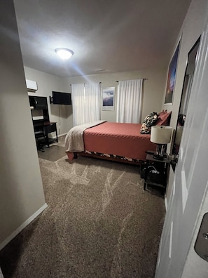 A bedroom with a bed, a desk, a chair, a lamp, and a picture on the wall. - CatalpaCorner 2-Bed Peace-filled/Sunroom/Turnkey/Mid-term/Monthly/Weekly (Springfield)