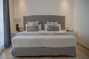 Une chambre d’hôtel avec un grand lit, deux tables de chevet, une lampe et un téléphone.