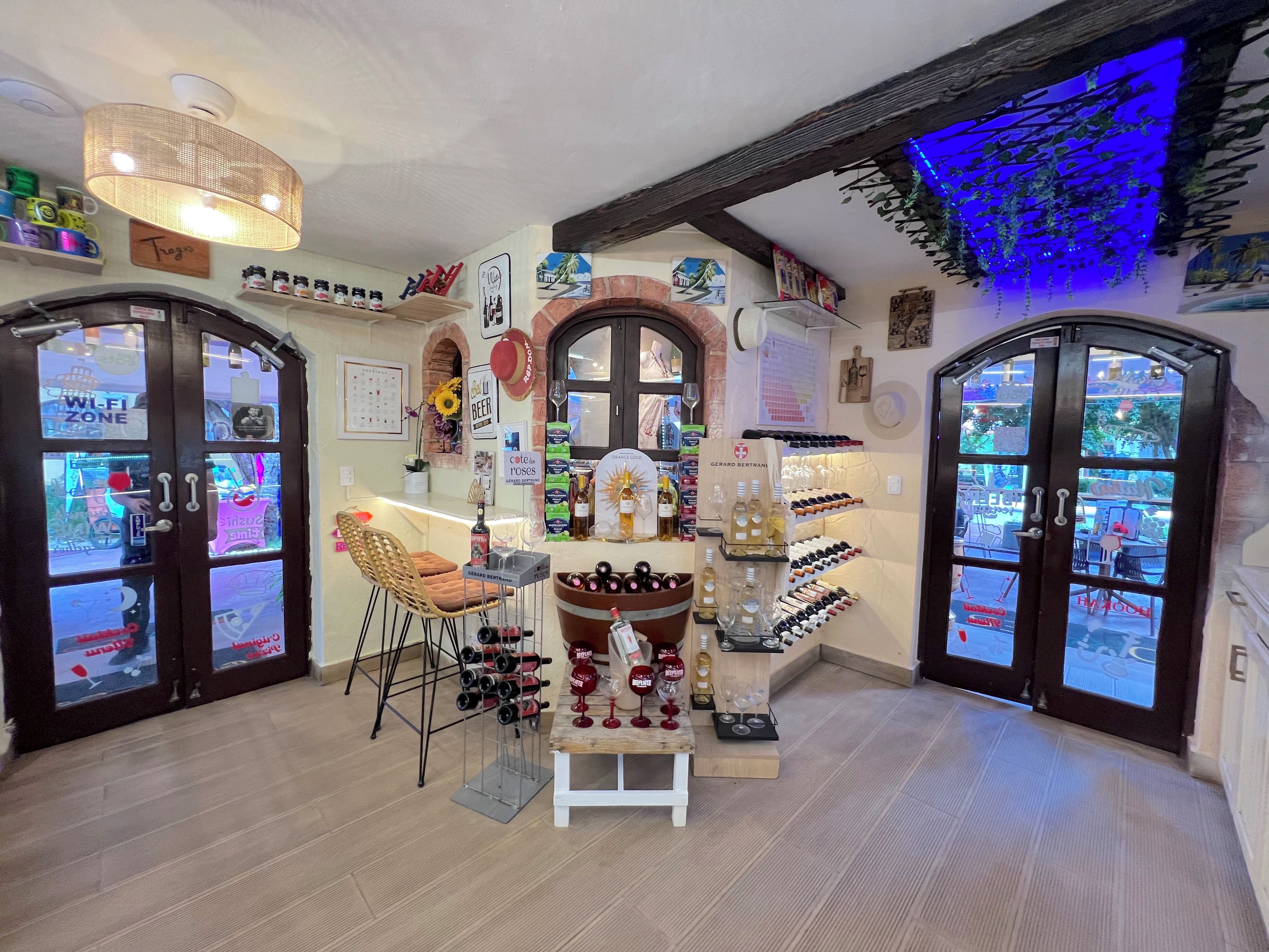 A cozy interior with a bar area, wine display, and a seating arrangement.