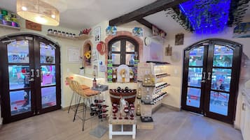 A cozy interior with a bar area, wine display, and a seating arrangement.