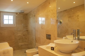 Une salle de bain moderne avec un grand lavabo, un miroir et un espace douche.
