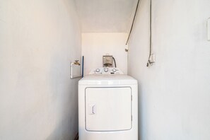 A laundry room with a front-loading washing machine, a water heater, and a power outlet. - Playas del Coco Condo w/ Pool: Near Beach! (Playas del Coco)