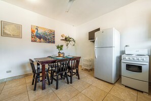 A kitchen with a dining table, chairs, a refrigerator, and an oven. - Near Beach! Playas del Coco Condo w/ Pool (Playas del Coco)