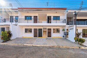 A two-story building with a flat roof, multiple balconies, and a gated entrance. - 1 Mi to Beach: Playas del Coco Condo w/ Pool (Playas del Coco)