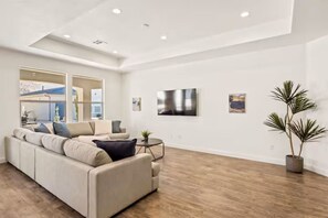 A modern living room with a sectional sofa, a small coffee table, and a potted plant.