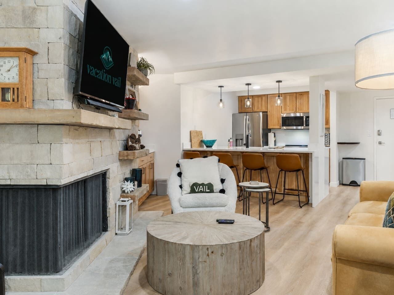 A modern living room with a fireplace, a TV mounted on the wall, a round coffee table, and a comfortable sofa.
