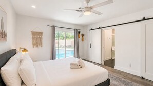 A bedroom with a bed, a ceiling fan, a sliding door, and a view of a swimming pool. - 6 bdrm 5bath in Old Town with Casita, Game Room, and Pool. Two Kitchens!  (Scottsdale)