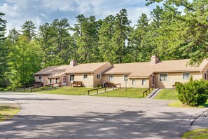 A row of cabins with a paved driveway and wooden benches. - Walk to Echo Lake State Park! Family Escape (Conway)