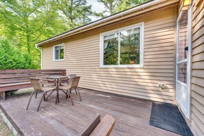 A wooden deck with a table and chairs, a bench, and a house with two windows. - Walk to Echo Lake State Park! Family Escape (Conway)