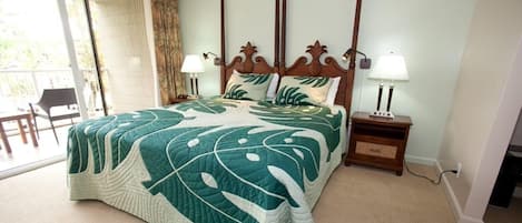 A hotel room with a large bed, two bedside lamps, a wooden headboard, and a view through a sliding glass door.