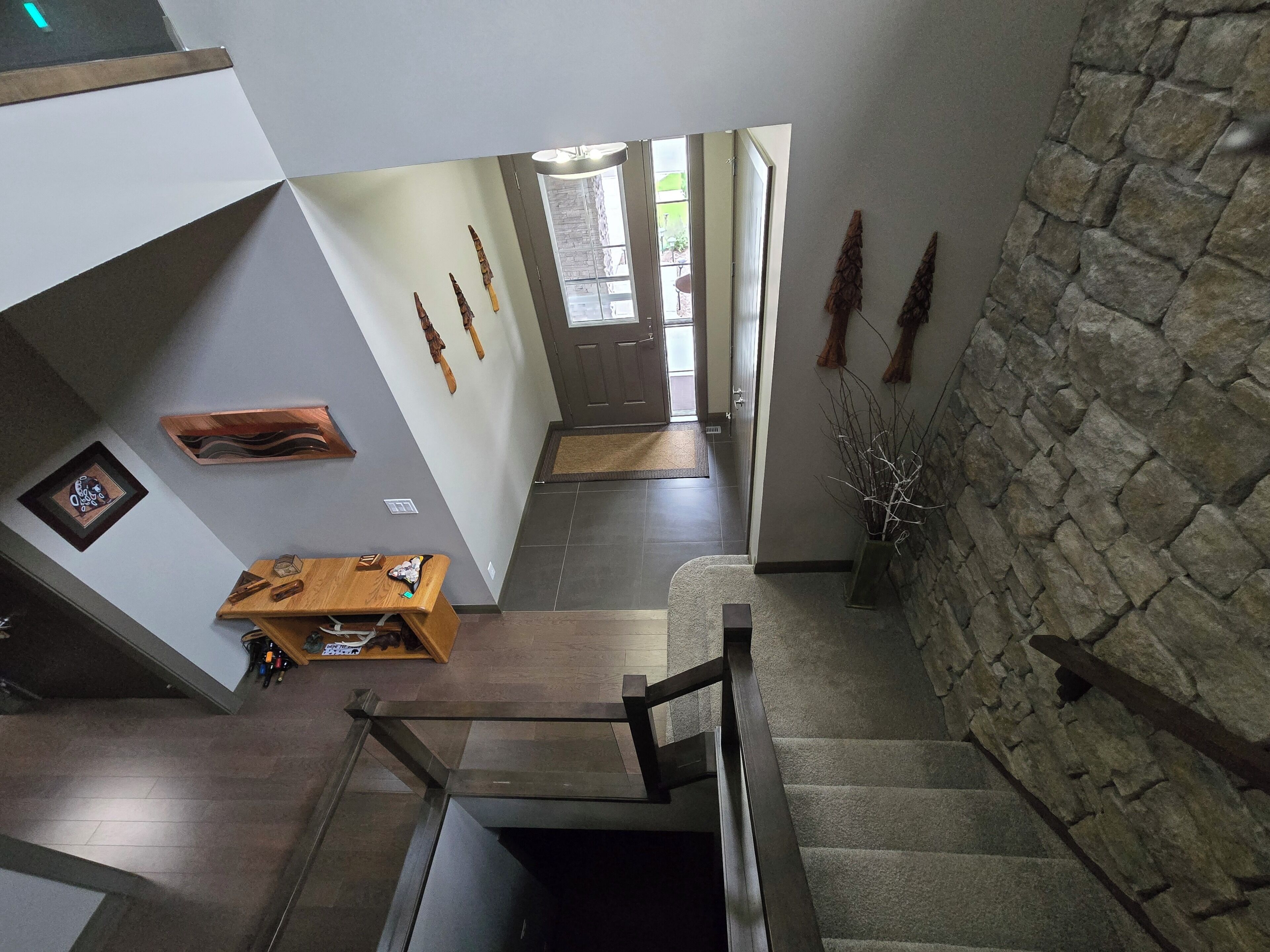 A staircase leading to a second floor with a stone wall and a door at the top.
