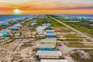A coastal residential area with houses and a road leading to the beach. - Mellow Yellow · New! Bay & Gulf Views, Steps to Beach, Sleeps 8 (Gulf Shores)