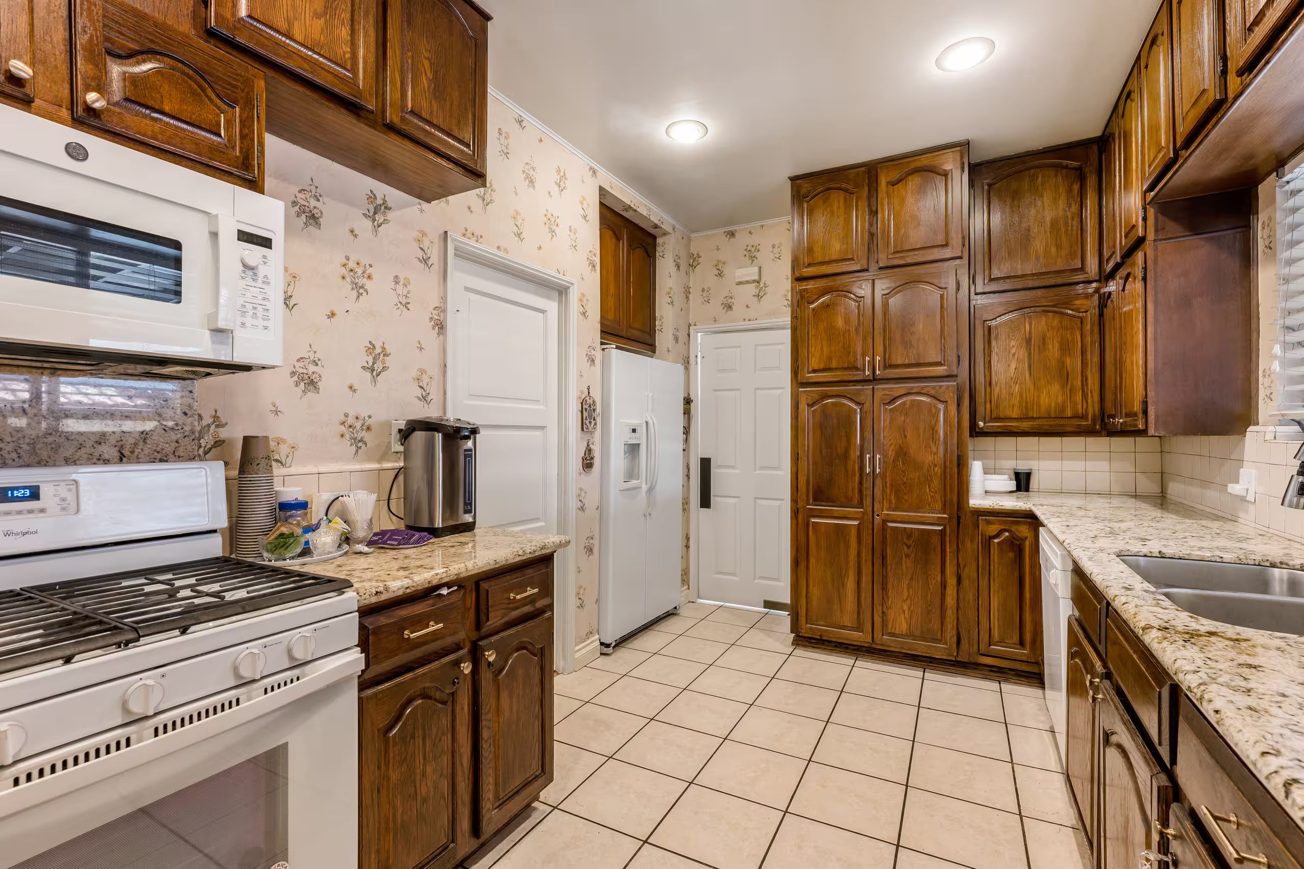 A kitchen with wooden cabinets, a microwave, a stove, and a refrigerator.
