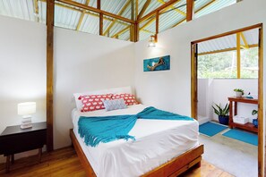 Ein Schlafzimmer mit einem hölzernen Bett, weißen Wänden und einem Oberlicht.