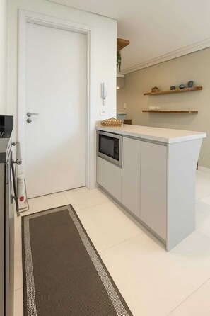 Eine kleine Küche mit einer Mikrowelle, einem kleinen Kühlschrank und einer Arbeitsfläche.