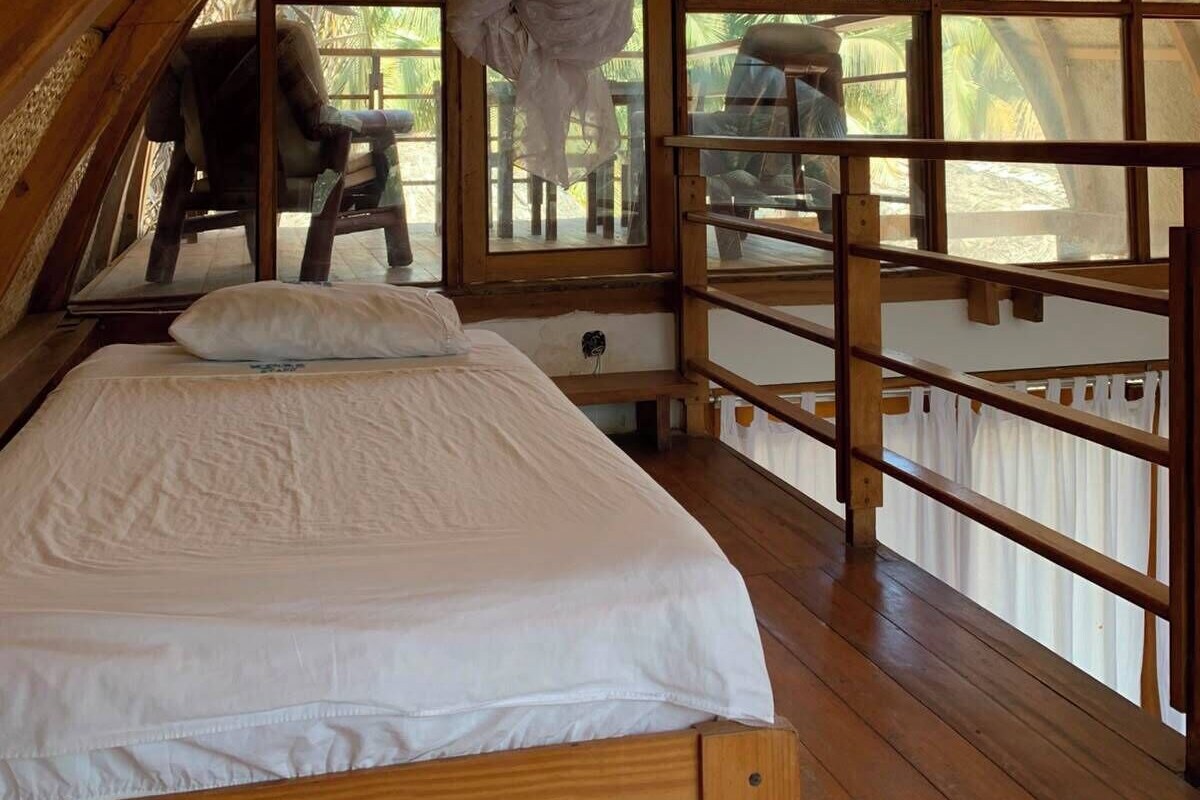 Een gezellige kamer met houten frame, een bed, een stoel en een tafel.