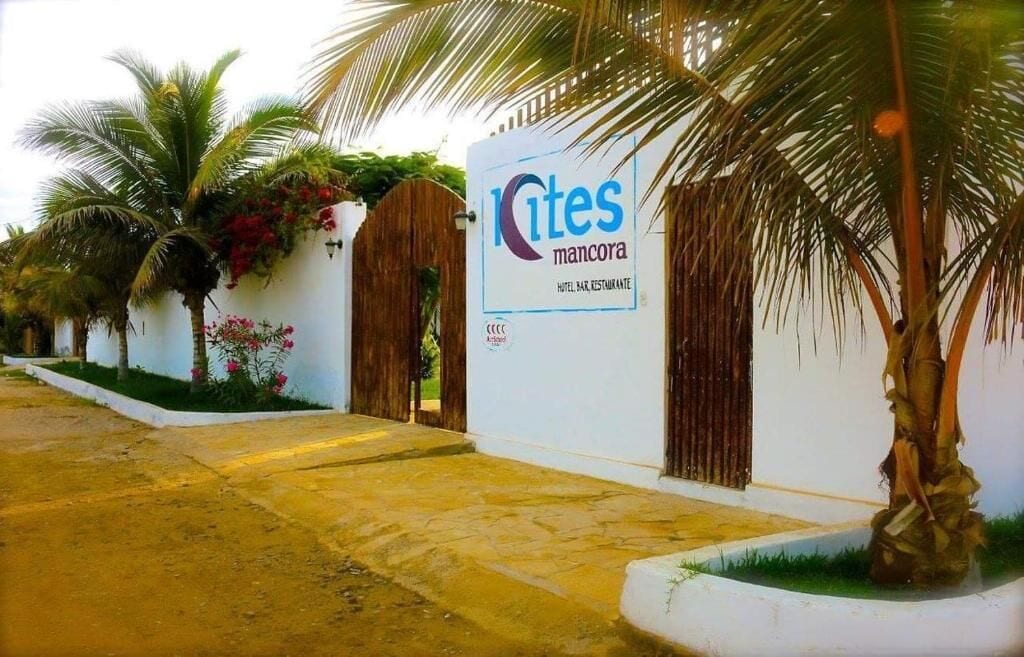 L’entrée d’un hôtel, avec une enseigne indiquant « Kites Mancora » et un portail en bois.