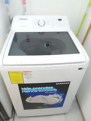 A Samsung washing machine with a label indicating energy efficiency and a capacity of 180 liters.