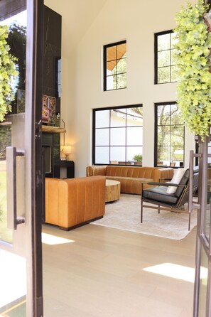A modern living room with a sectional sofa, a coffee table, and a fireplace. - Maison Blanche I French-Inspired Retreat on 2.5 Acres I Sleeps 13 (Austin)